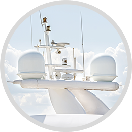 Modern Marine Radar Antenna Array Close-up of a modern radar antenna array on a marine vessel, featuring multiple radar domes and communication equipment under a clear sky.